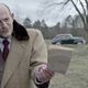 Christopher Lloyd holding a piece of paper.